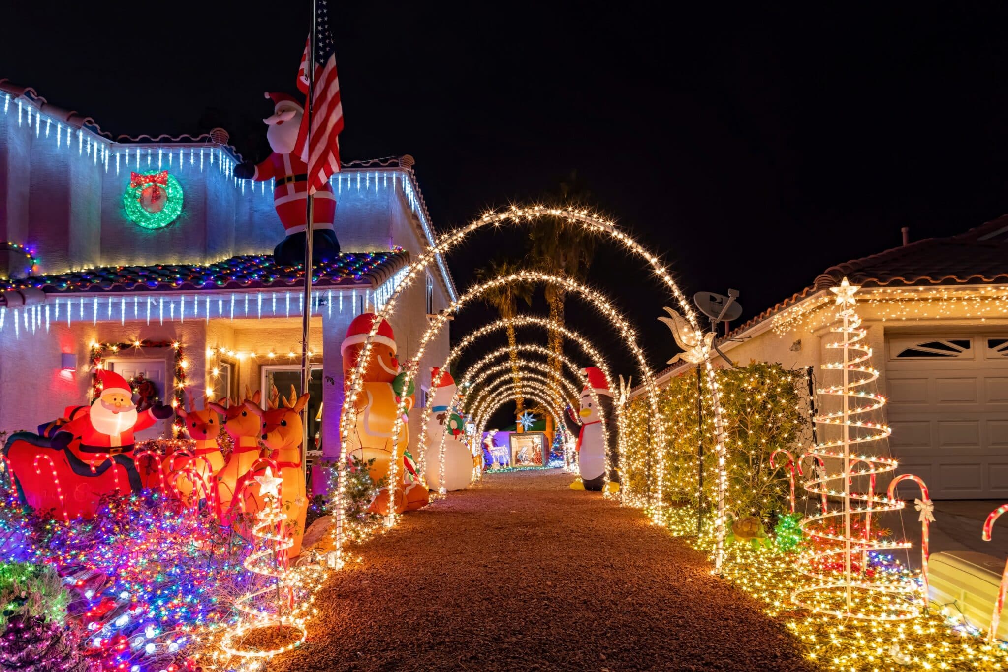 Full festive holiday house decorated with precision warm white roofline and landscape lights